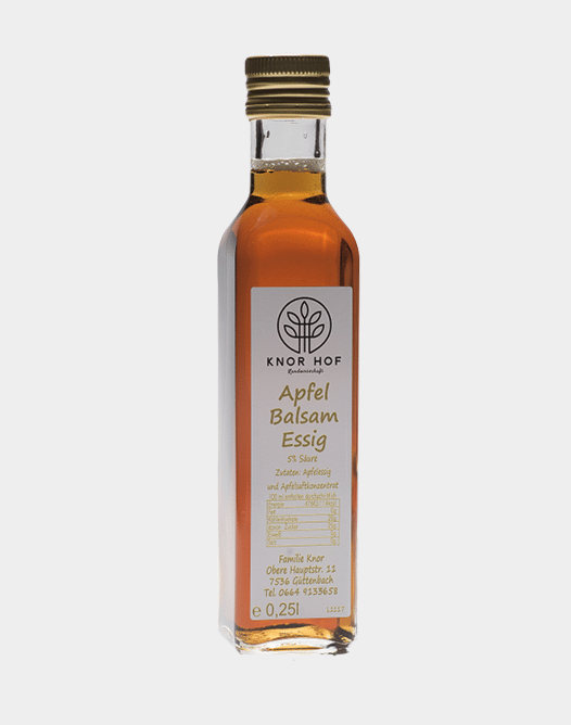 Eine Glasflasche Apfel Balsam Essig mit goldenem Deckel, perfekt zum Verfeinern Ihres Schwäbischen Kartoffelsalats. Das Etikett zeigt Text und Logo, während der Essig im Inneren in einer goldenen Bernsteinfarbe schimmert.